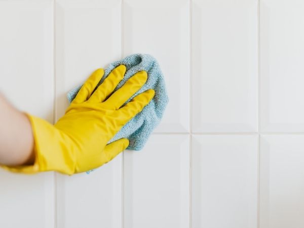 une main gantée qui nettoie une surface